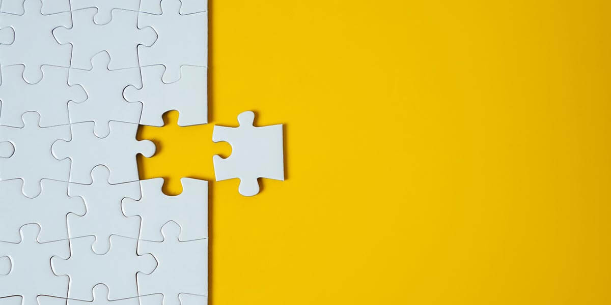 Grey puzzle piece on a yellow background 